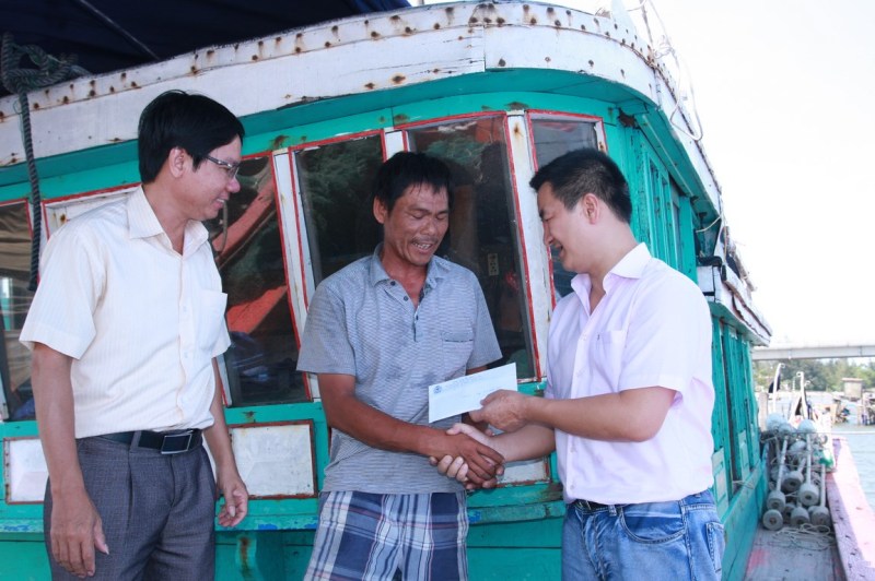 Đại diện Quỹ TTXH Tấm lòng vàng Lao động trao tiền hỗ trợ cho ngư dân Bùi Đình Biền bị tàu Trung Quốc phá hoại ngư lưới cụ.