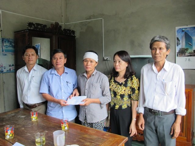 Đ/c Trần Văn Bến -Phó Chủ tịch LĐLĐ tỉnh (thứ hai bên trái sang) trao tiền hỗ trợ cho gia đình anh Nguyễn Cao Kỳ